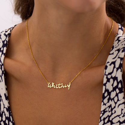 Italic script name necklace in 14K gold, worn on model