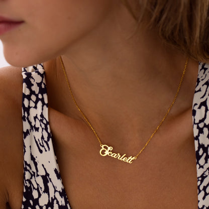 Elegant swirl name necklace in 14K gold, worn on model