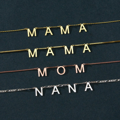 Custom word necklace with letter pendants, 14K gold vermeil, letter options flat lay on green fabric