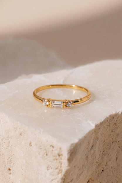 Baguette and round lab-grown diamond ring in 14K solid gold, on a stone surface