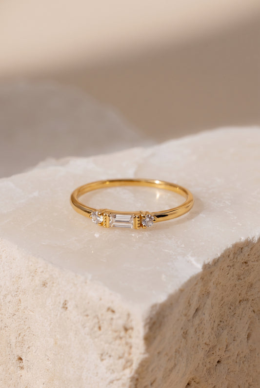 Baguette and round lab-grown diamond ring in 14K solid gold, on a stone surface