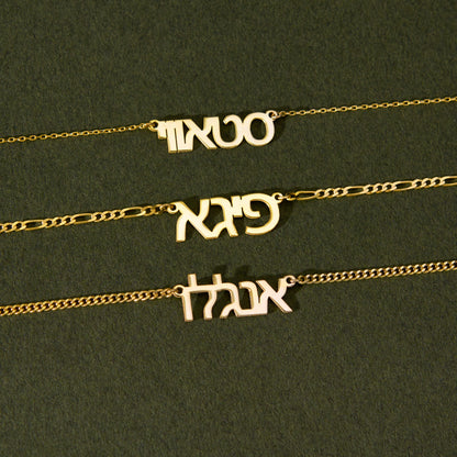 Custom Hebrew name necklace, 14K gold vermeil, name pendant flat lay on green fabric