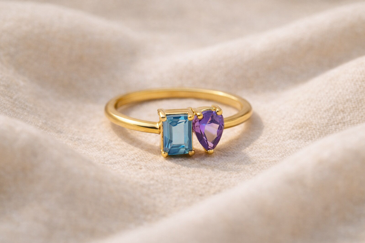Two stone birthstone ring with prong set emerald-cut and pear-cut stones