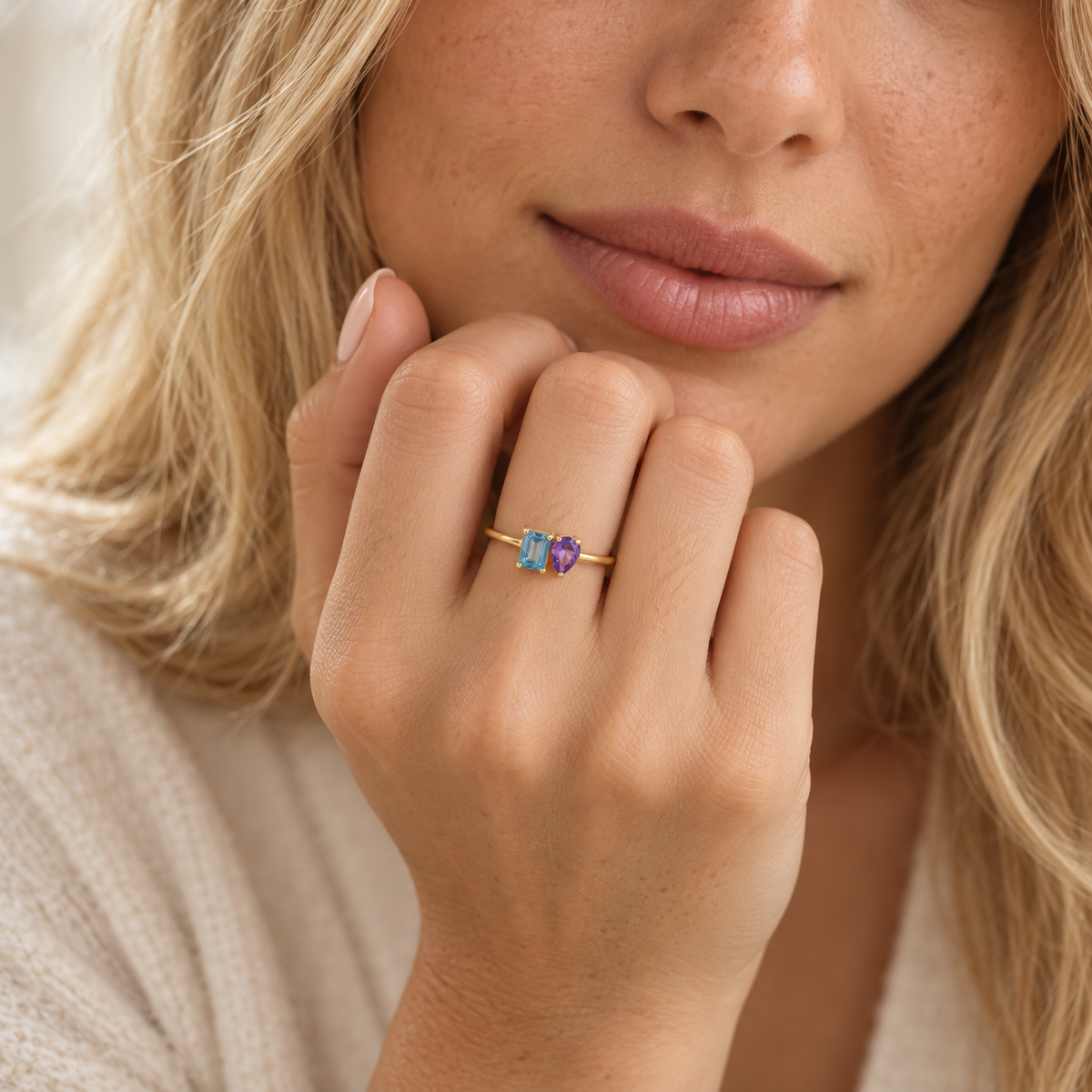 Hand wearing custom two stone birthstone ring with emerald-cut and pear-cut stones
